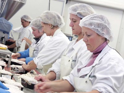 Līniju darbinieki pastēšu fabrikā